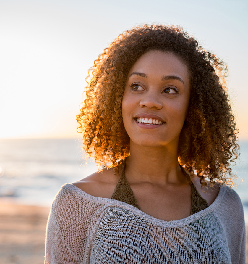 Woman smiling, looking off into the distance.